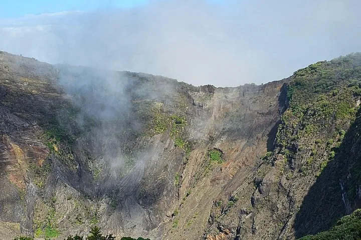 Steile felsige Kraterwände des Irazú-Vulkans mit Nebel und Vegetation